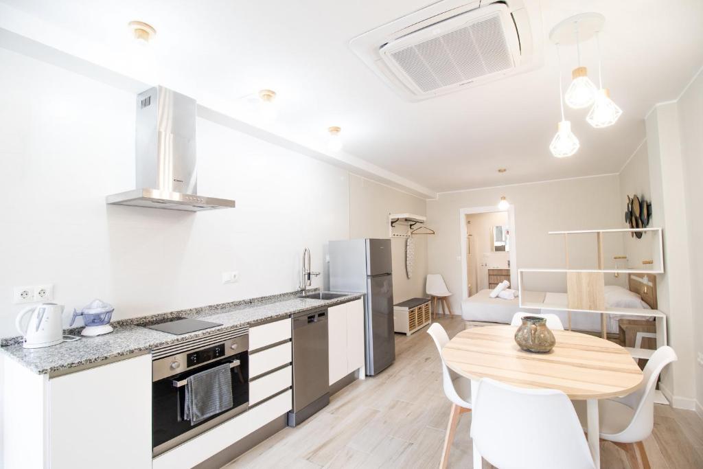 a kitchen and dining room with a table and chairs at Nautical Flats by Concept in Valencia