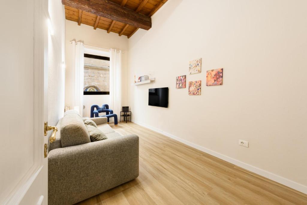 a living room with a couch and a tv at Orsanmichele View by Mmega in Florence