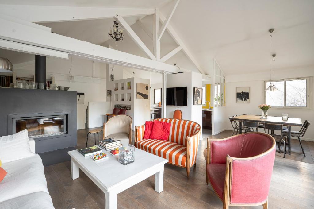 een woonkamer met een bank, stoelen en een tafel bij Atypical Luxury House near Paris in Boulogne-Billancourt