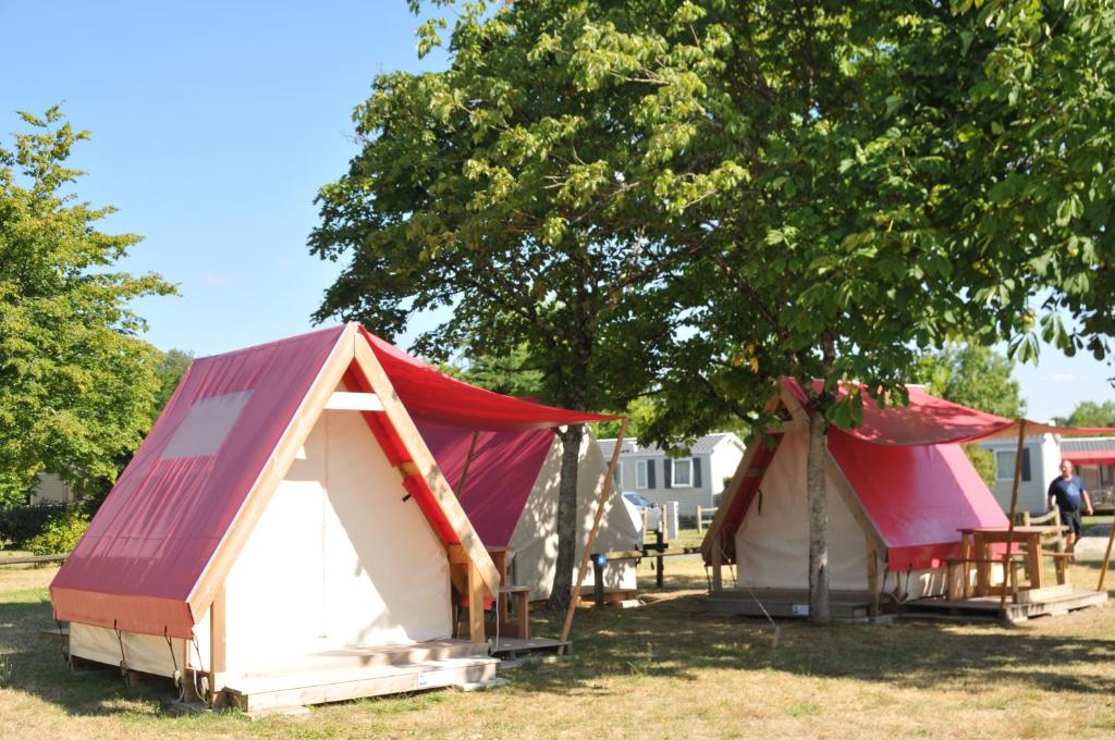 a group of tents sitting under a tree at Camping La Mignardière in Ballan-Miré