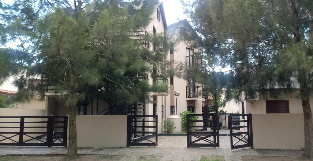 un edificio blanco con una puerta y un árbol en Complejo Arena Malva en San Bernardo