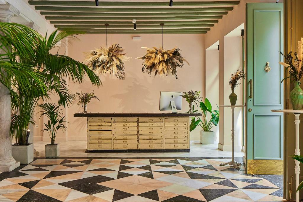 a lobby with palm trees and a counter at VG - Villa de Andas suites in Cádiz