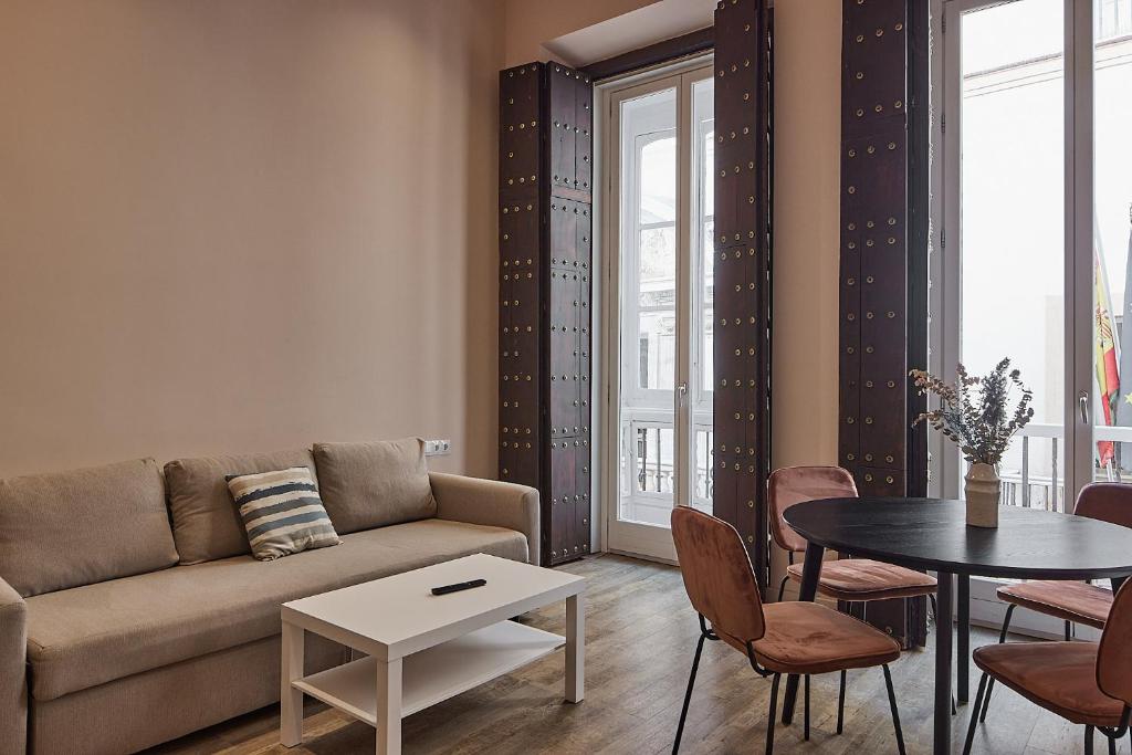 a living room with a couch and a table at VG - Villa de Andas suites in Cádiz