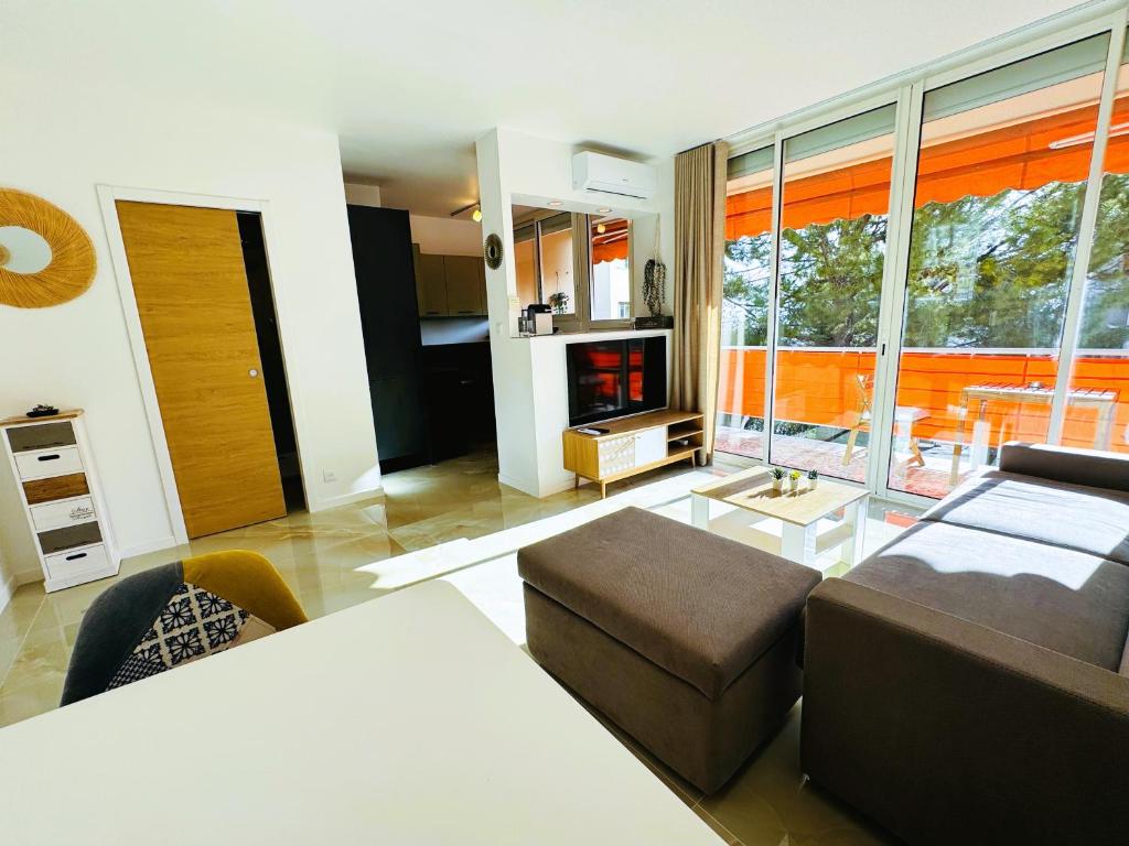 un grand salon avec un canapé et une table dans l'établissement Studio climatisé 600m de la plage, à Cagnes-sur-Mer