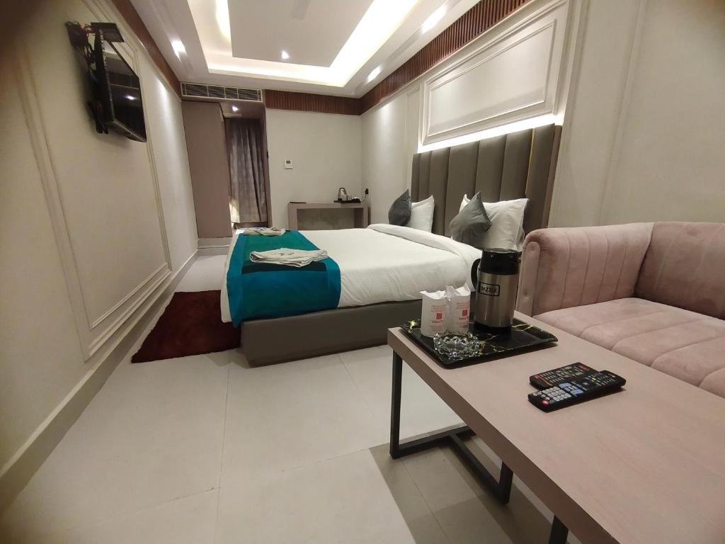 a hotel room with a bed and a couch at Hotel Gagan Plaza in Kānpur