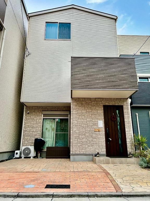 una casa blanca con una puerta negra en Free Parking Namba south Villa 4 rooms 120m2 en Osaka