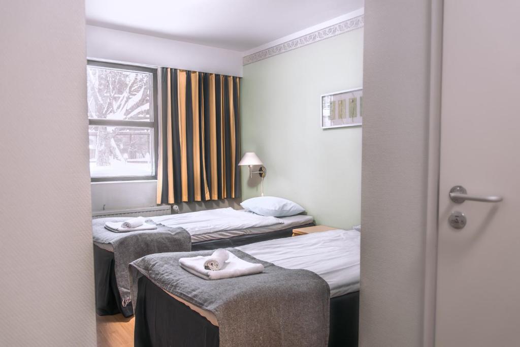 Postel nebo postele na pokoji v ubytování Hotelli Tiiliriihi
