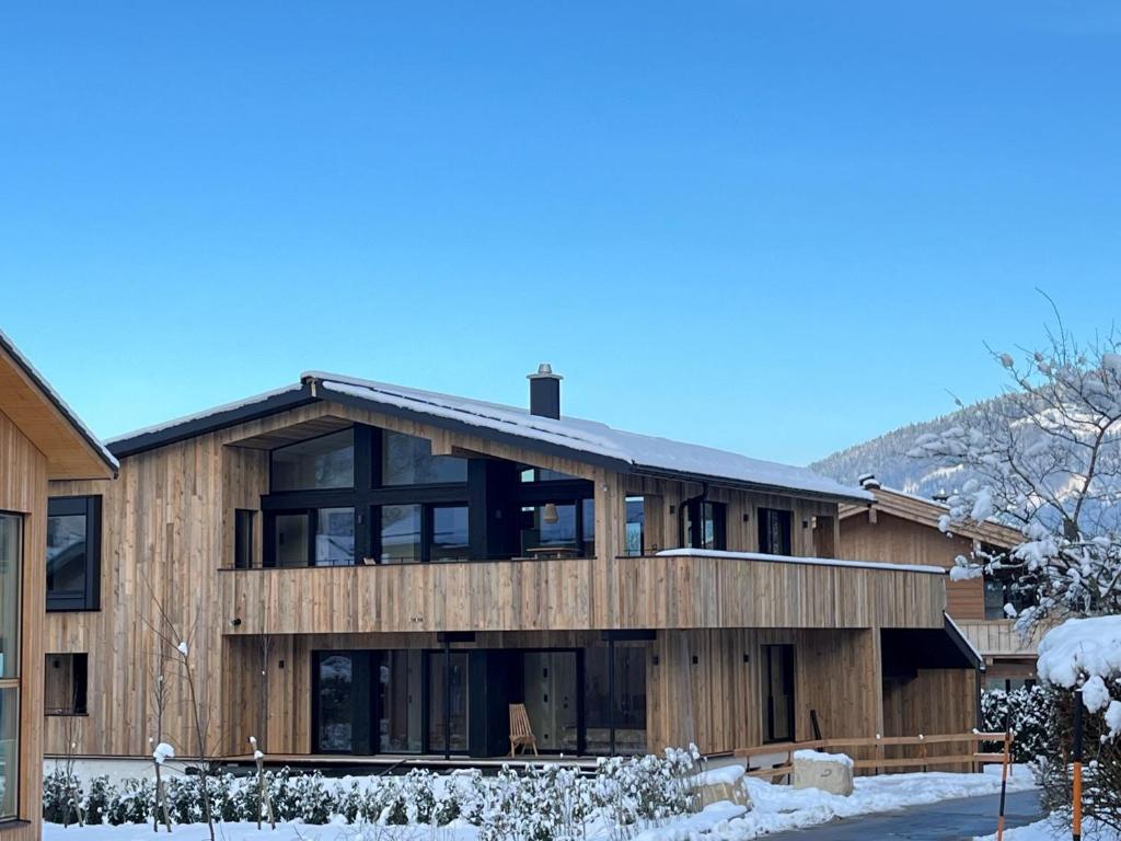 een groot houten huis in de sneeuw bij Alpenlodges in Schönau am Königssee