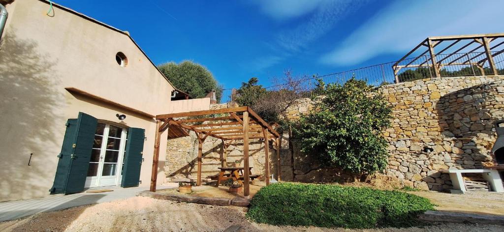 un bâtiment avec un banc en bois devant lui dans l'établissement Cinsault, à La Cadière-dʼAzur