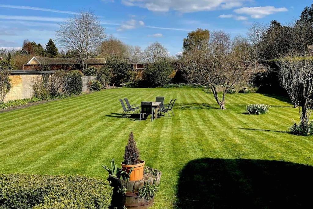 a lawn with a table and chairs in a yard at Large Historic Secret Hideaway in Moreton in Marsh