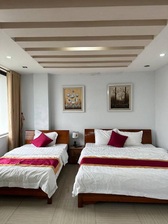 a bedroom with two beds with red and white sheets at Thiên Thiên Thanh in Lao Cai