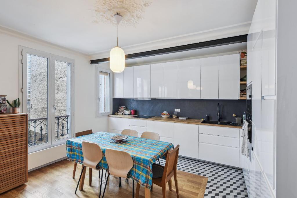 a kitchen and dining room with a table and chairs at Duplex familial à necker by Weekome in Paris