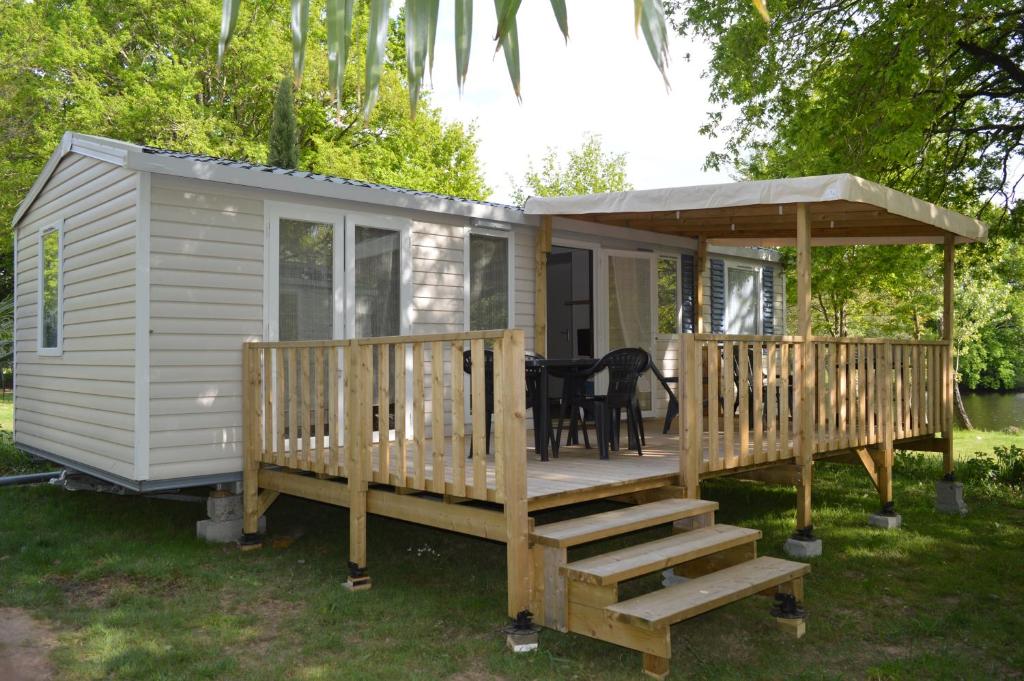 ein kleines Haus mit einer Terrasse und einem Pavillon in der Unterkunft mobil home in Sainte-Reine-de-Bretagne