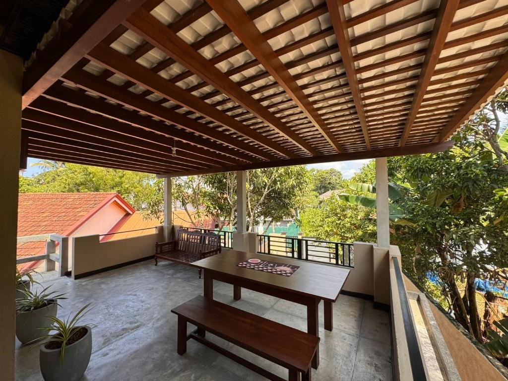 a wooden pergola on a patio with a table at Serenique Heaven in Hikkaduwa