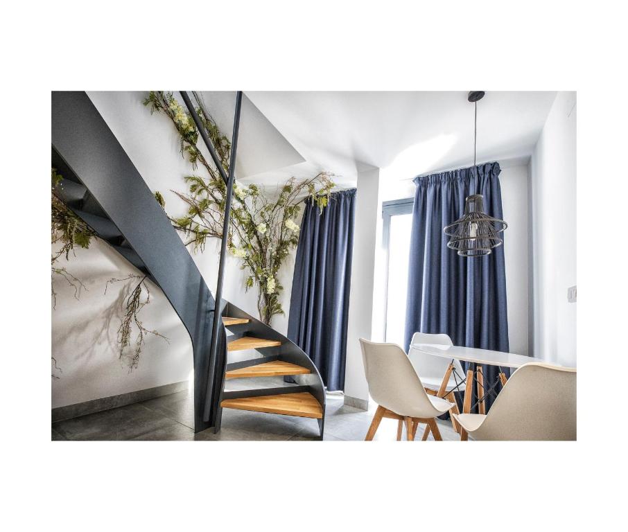 una escalera en una habitación con sillas y mesa en Riam suites apartamentos, en Los Palacios y Villafranca