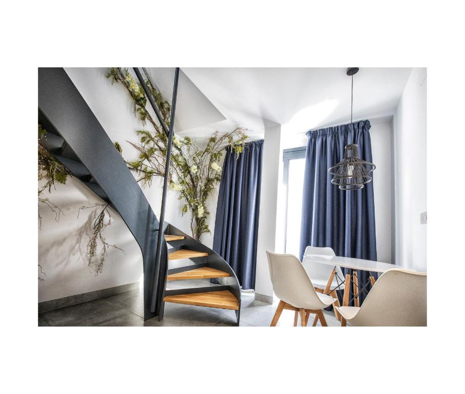 a staircase in a room with chairs and a table at Riam suites apartamentos in Los Palacios y Villafranca