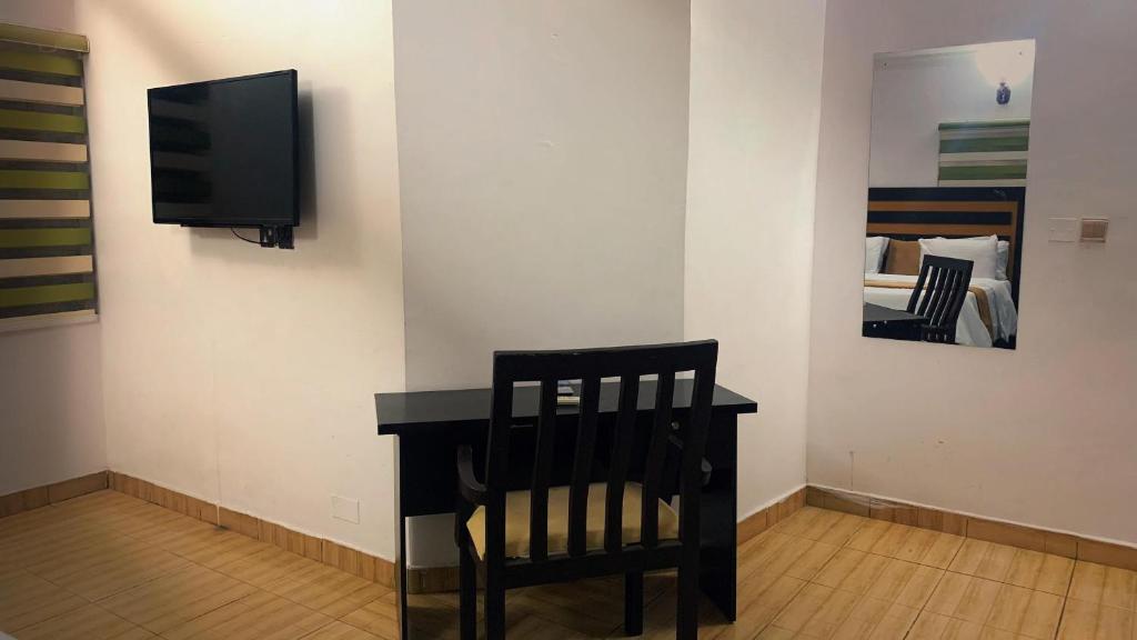 a room with a chair and a television on a wall at WORK AND PLAY PLACE(WPP) in Ikeja