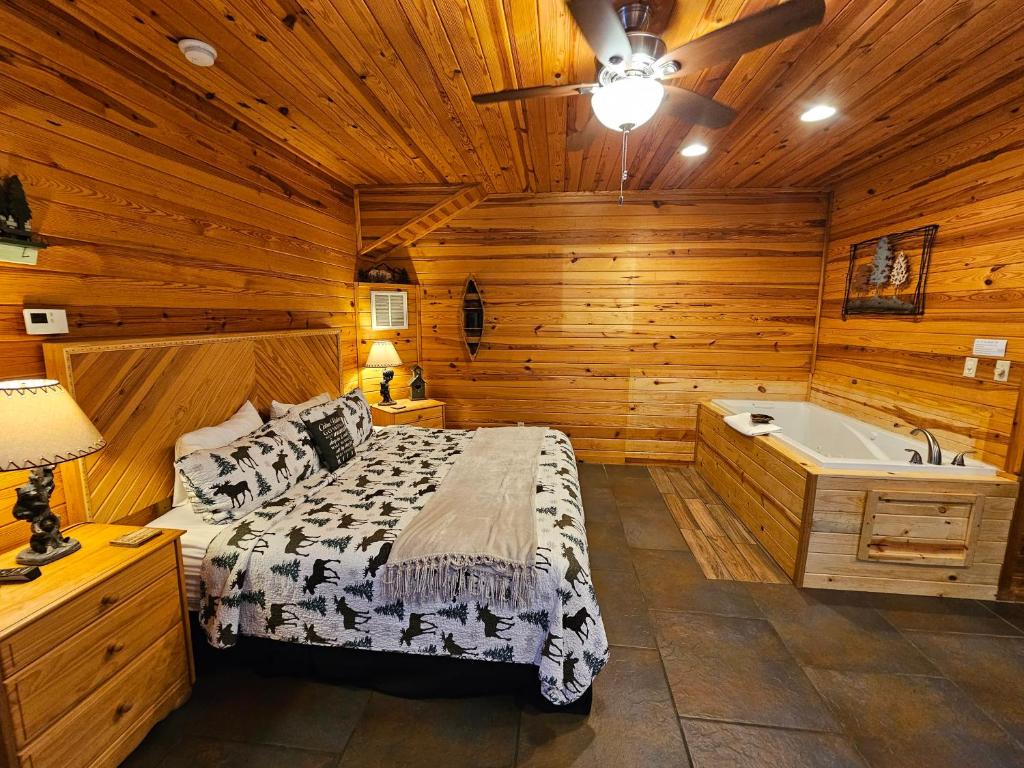 a bedroom with a bed and a bath tub at Honey Bear Haven Suite 1 in Eureka Springs