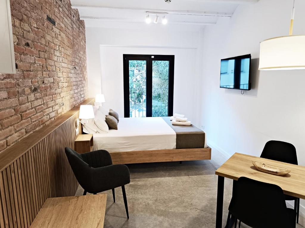 略夫雷加特河畔奥斯皮塔莱特ARIQUS Fira Apartments的一间带床和砖墙的卧室
