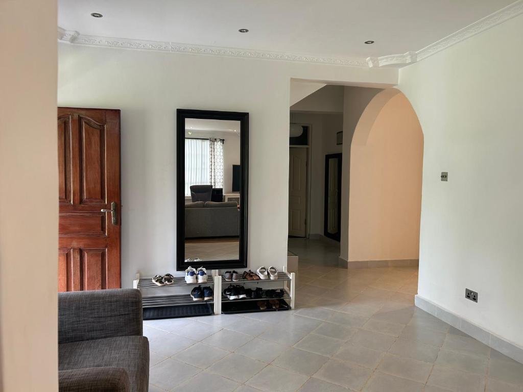 uma sala de estar com um espelho e um sofá em Cinnamon House em Kisumu