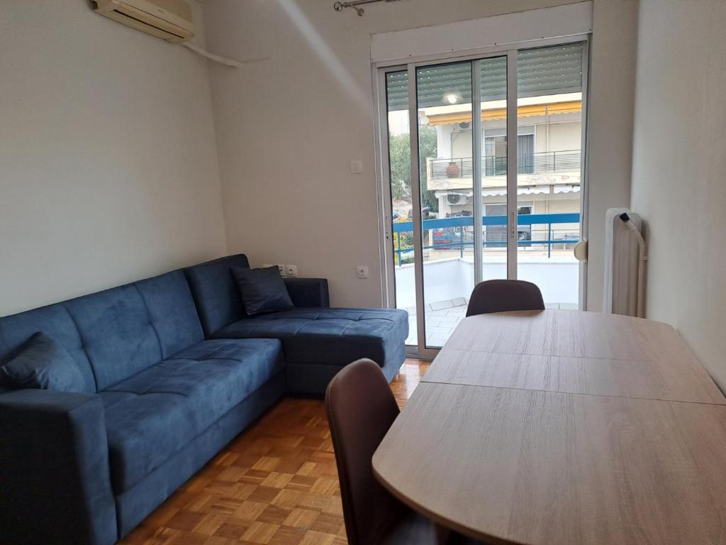 uma sala de estar com um sofá azul e uma mesa em Spitaki em Kavala