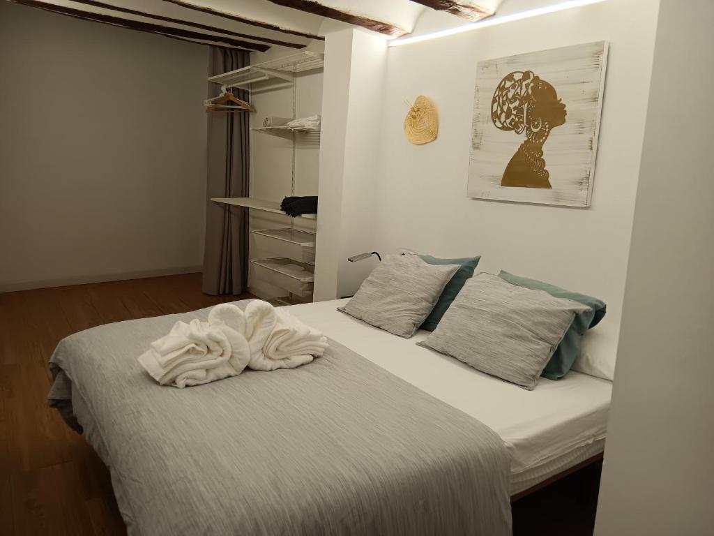 Un dormitorio con una cama con una toalla. en EL RINCÓN deMANUELA, en Requena