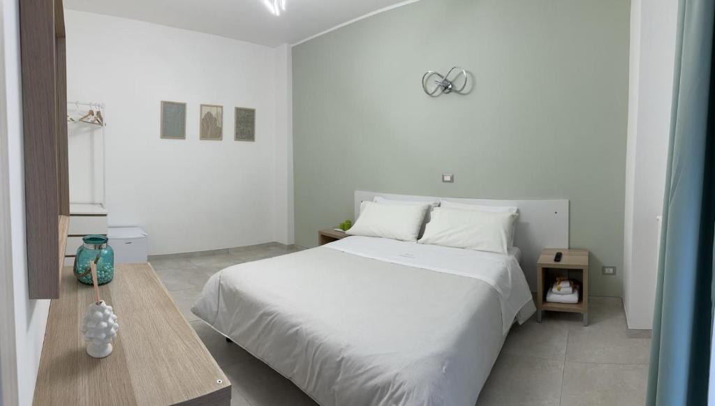 Un dormitorio blanco con una cama grande y una mesa en Perla Saracena, en Lucera