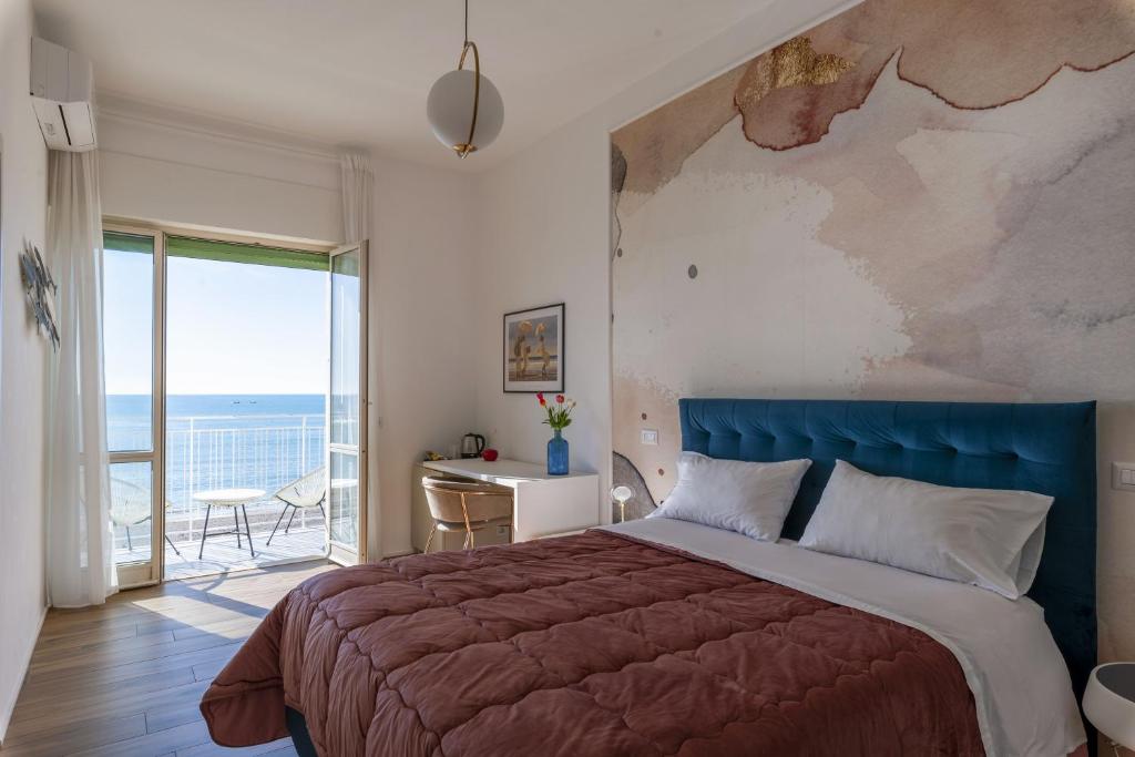a bedroom with a bed and a view of the ocean at Cas’ A Mare - Beachfront Luxury Suites in Salerno