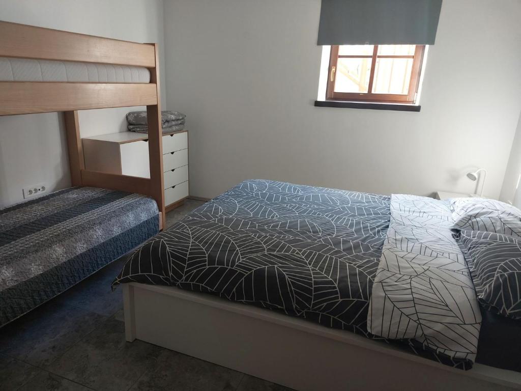 ein Schlafzimmer mit einem Bett und einem Etagenbett aus Holz in der Unterkunft APARTMAJI VITEZ in Bovec