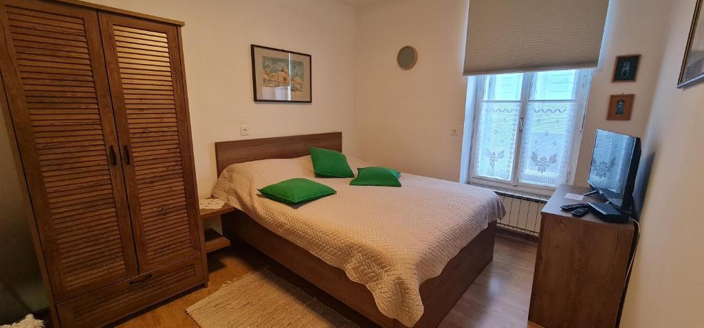 Un dormitorio con una cama con almohadas verdes. en APARTMA DOMENIKA en Ptuj