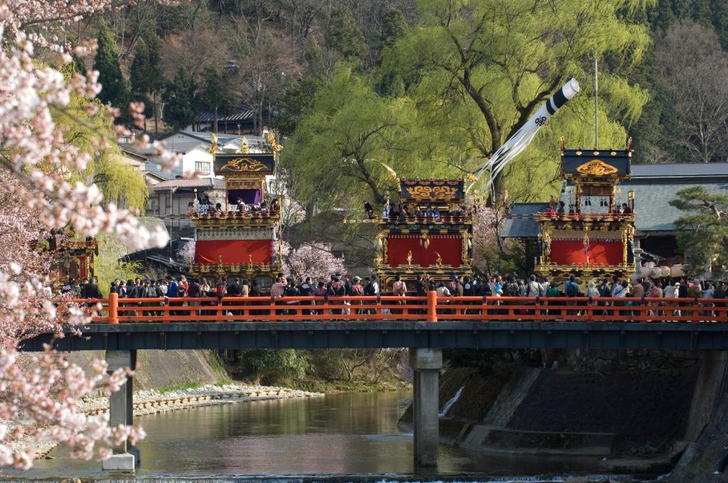 a group of people standing on a bridge at Hida Takayama Onsen Takayama Green Hotel - KEIO GROUP HOTELS - in Takayama