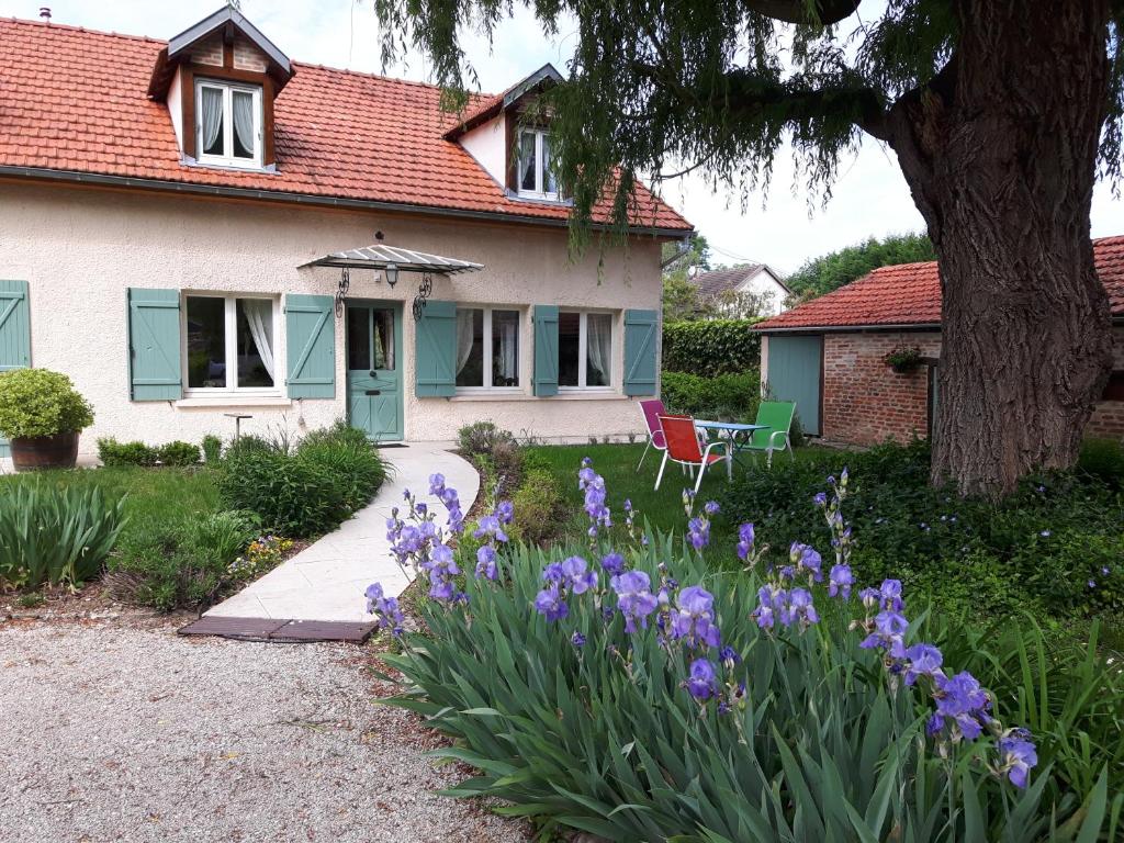 une maison avec des fleurs violettes dans la cour avant dans l'établissement B&B Les Cistelles, à Saint-Nicolas-lès-Cîteaux