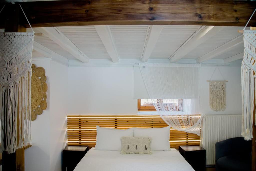 a bedroom with a bed with white sheets and a window at YARD- Family retreat in Kórinthos