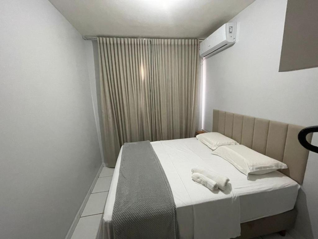 Un pequeño dormitorio con una cama con toallas. en Condomínio Colina, en Palmas