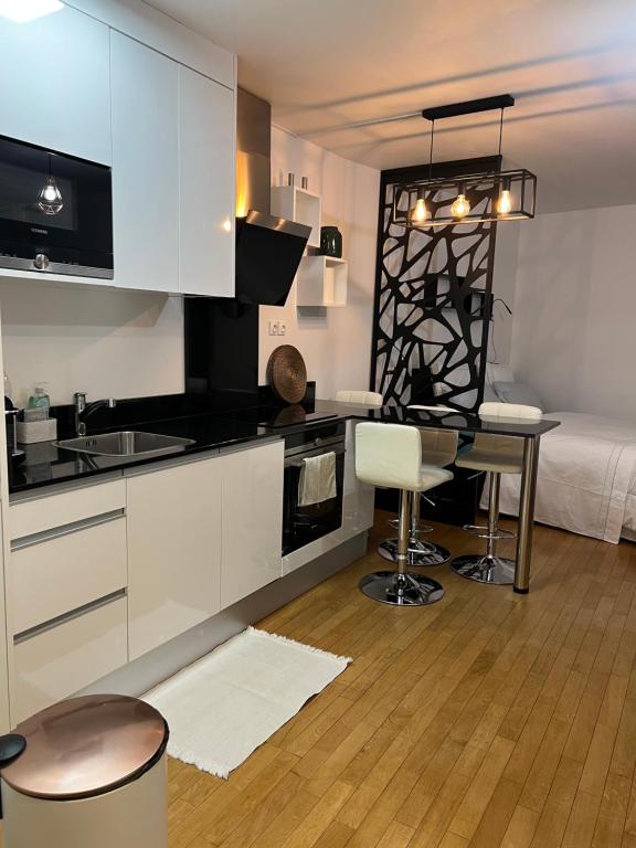 - une cuisine avec un évier et un bureau dans la chambre dans l'établissement Superbe studio Paris La Défense, à La Garenne-Colombes