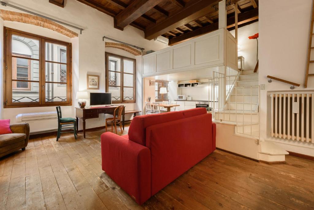 a living room with a red couch and a table at Lambertesca Loft in Florence