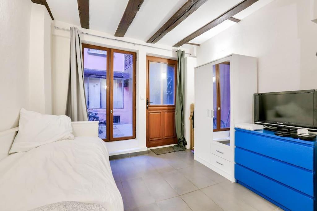 - une chambre avec une télévision et une commode bleue dans l'établissement Charming studio historical center of Strasbourg, à Strasbourg