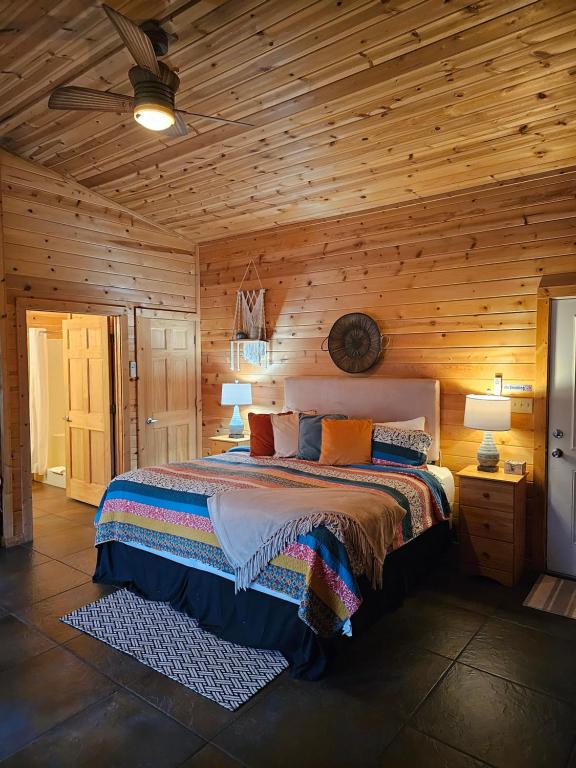 ein Schlafzimmer mit einem Bett in einer Holzhütte in der Unterkunft Honey Bear Haven Suite 4 in Eureka Springs