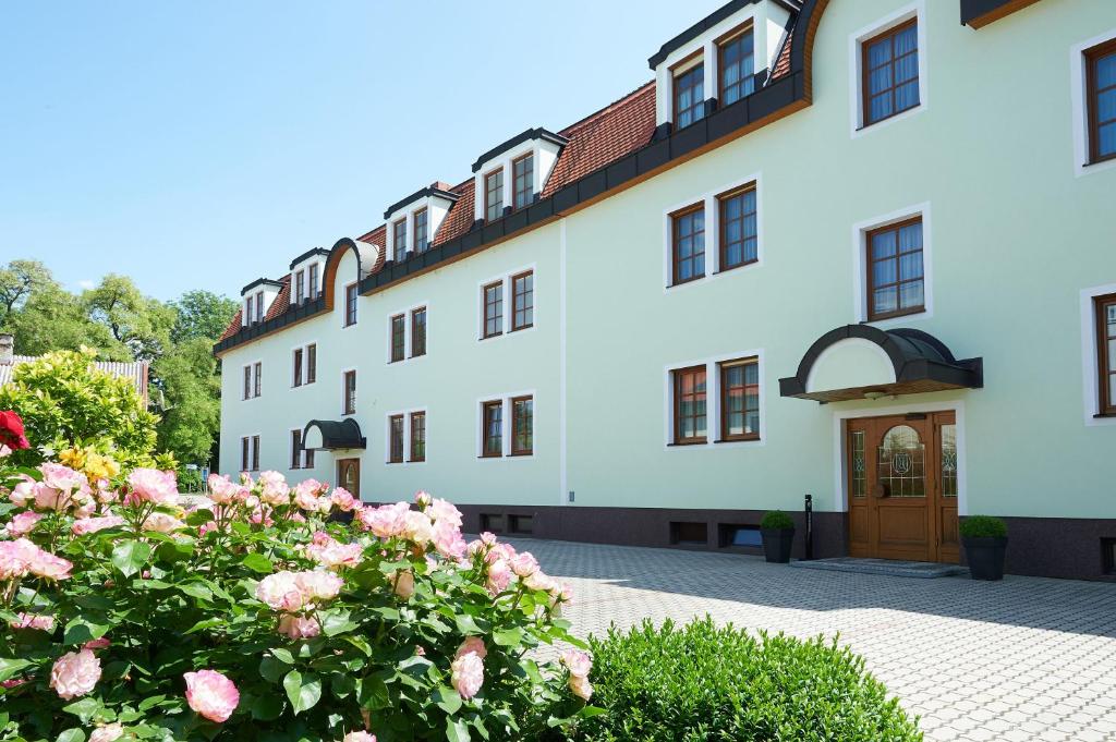 a building with pink roses in front of it at Pension Sprinzl in Schwechat