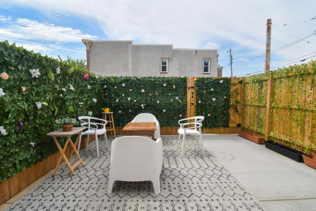 a patio with chairs and a fence with flowers at Beautiful Home w/ Rooftop Deck Within A 5 Mintue Walk To Johns Hopkins Hospital in Baltimore