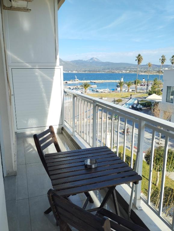 a wooden bench on a balcony with a view of the ocean at Pegasus Blossom in Korinthos