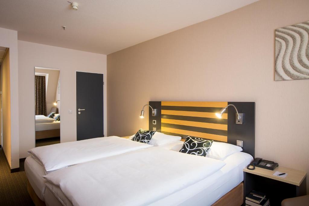 Postel nebo postele na pokoji v ubytování Lindner Hotel Frankfurt Hochst, part of JdV by Hyatt