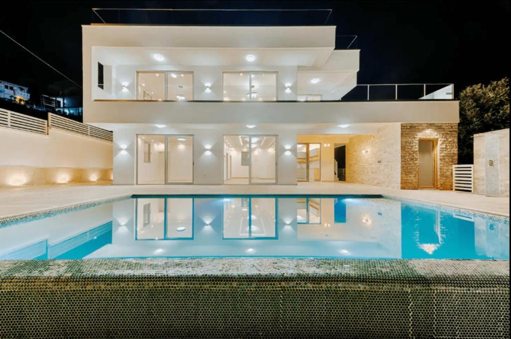 uma villa com piscina à noite em Villa Elia em Utjeha