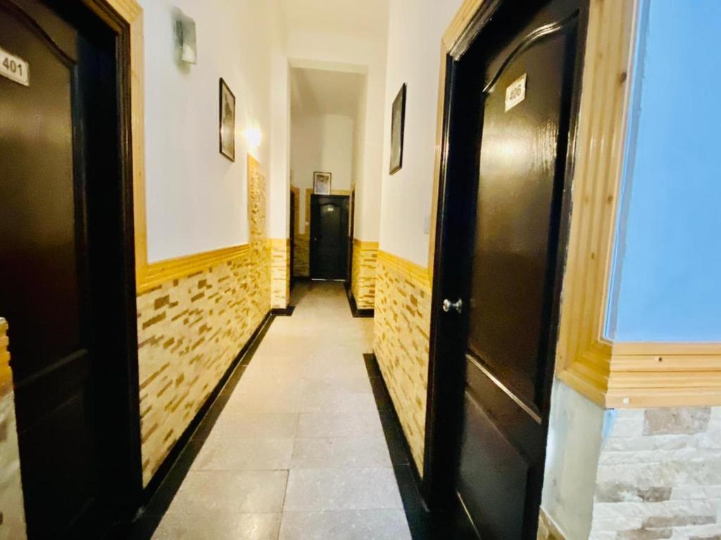 a hallway with black doors and a tile floor at Aachman velly view with terrace in Shimla