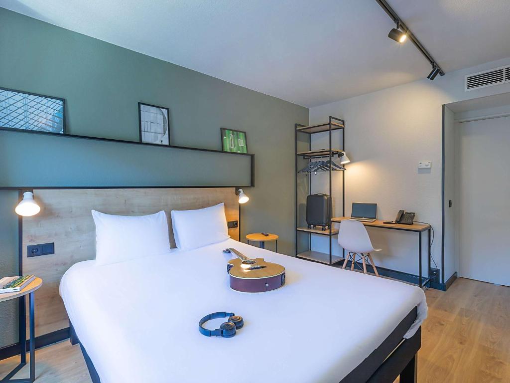 Hotel ibis Bragança في براغانزا: غرفة نوم مع سرير أبيض كبير ومكتب
