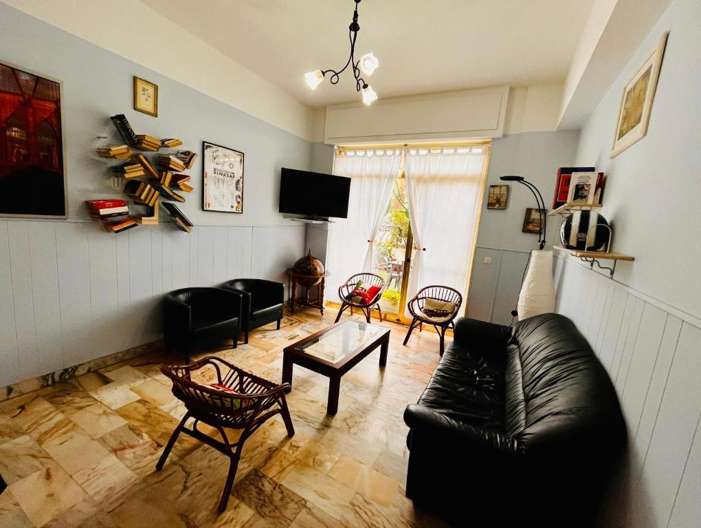 a living room with a black leather couch and chairs at Hotel Principe in Pietra Ligure