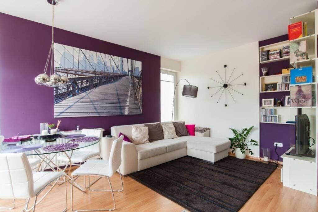 a living room with a white couch and a purple wall at Skydive in Budapest
