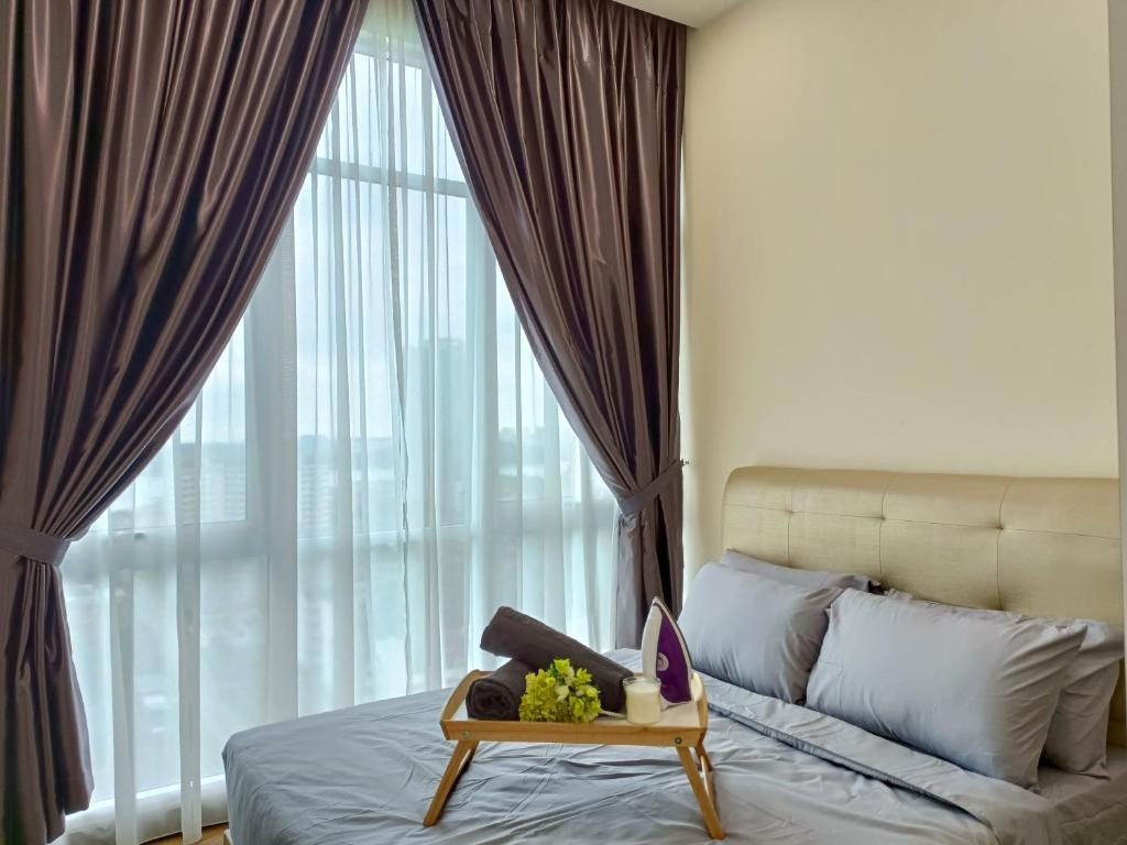 a bedroom with a bed with a table and a large window at Paragon Suite Homestay by Antlerzone in Johor Bahru
