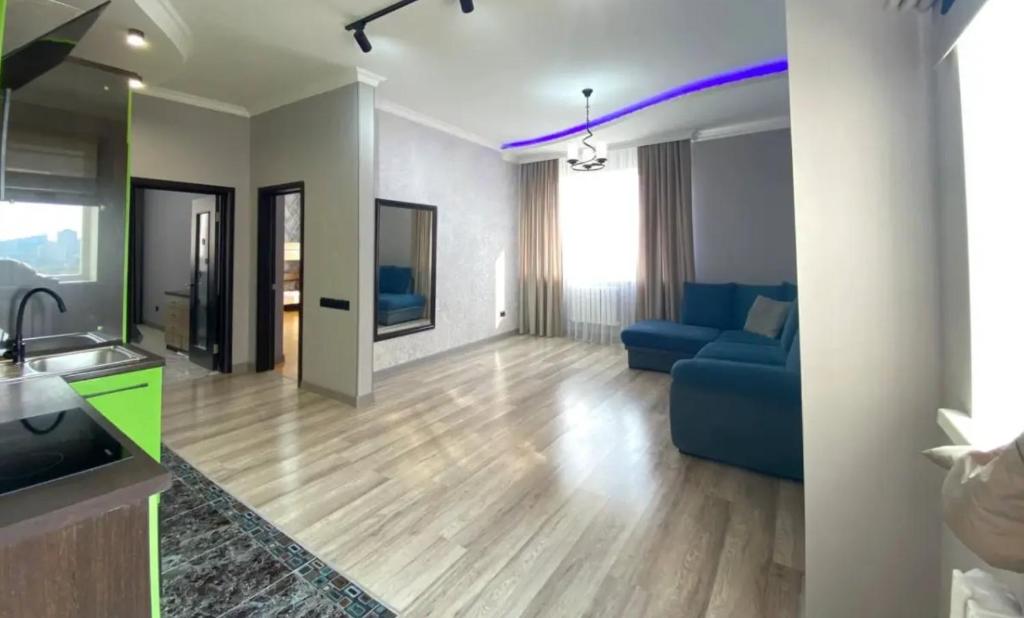 salon z niebieską kanapą i kuchnią w obiekcie 3х комнатная квартира в Астане w mieście Astana
