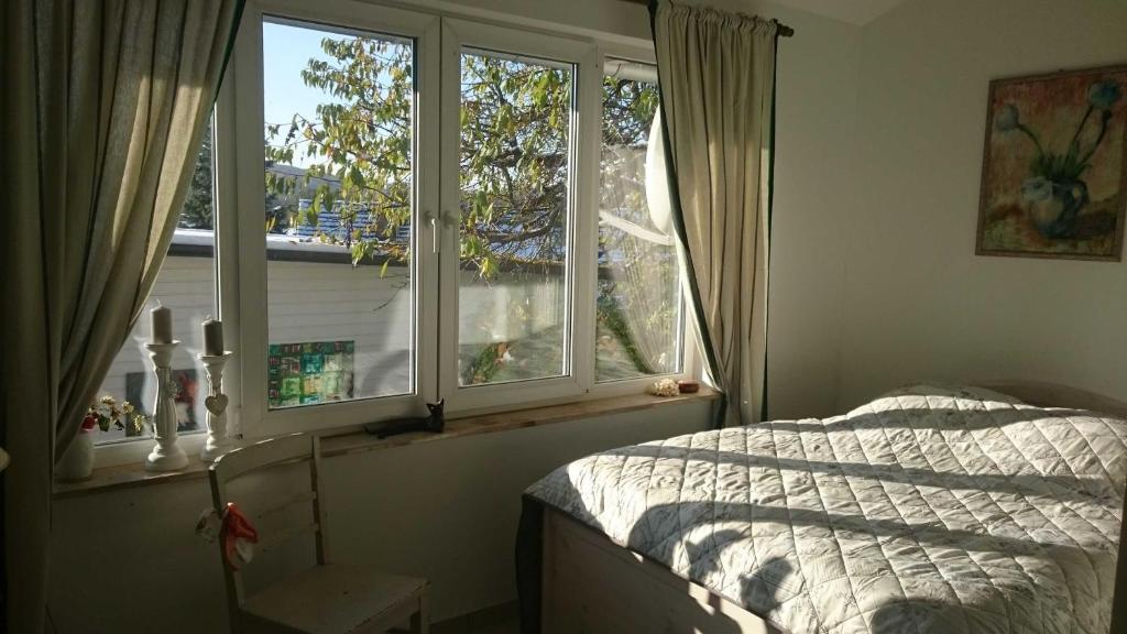 ein Schlafzimmer mit zwei Fenstern und einem Bett darin in der Unterkunft b Ferienhaus Unterfranz II b in Bad Doberan